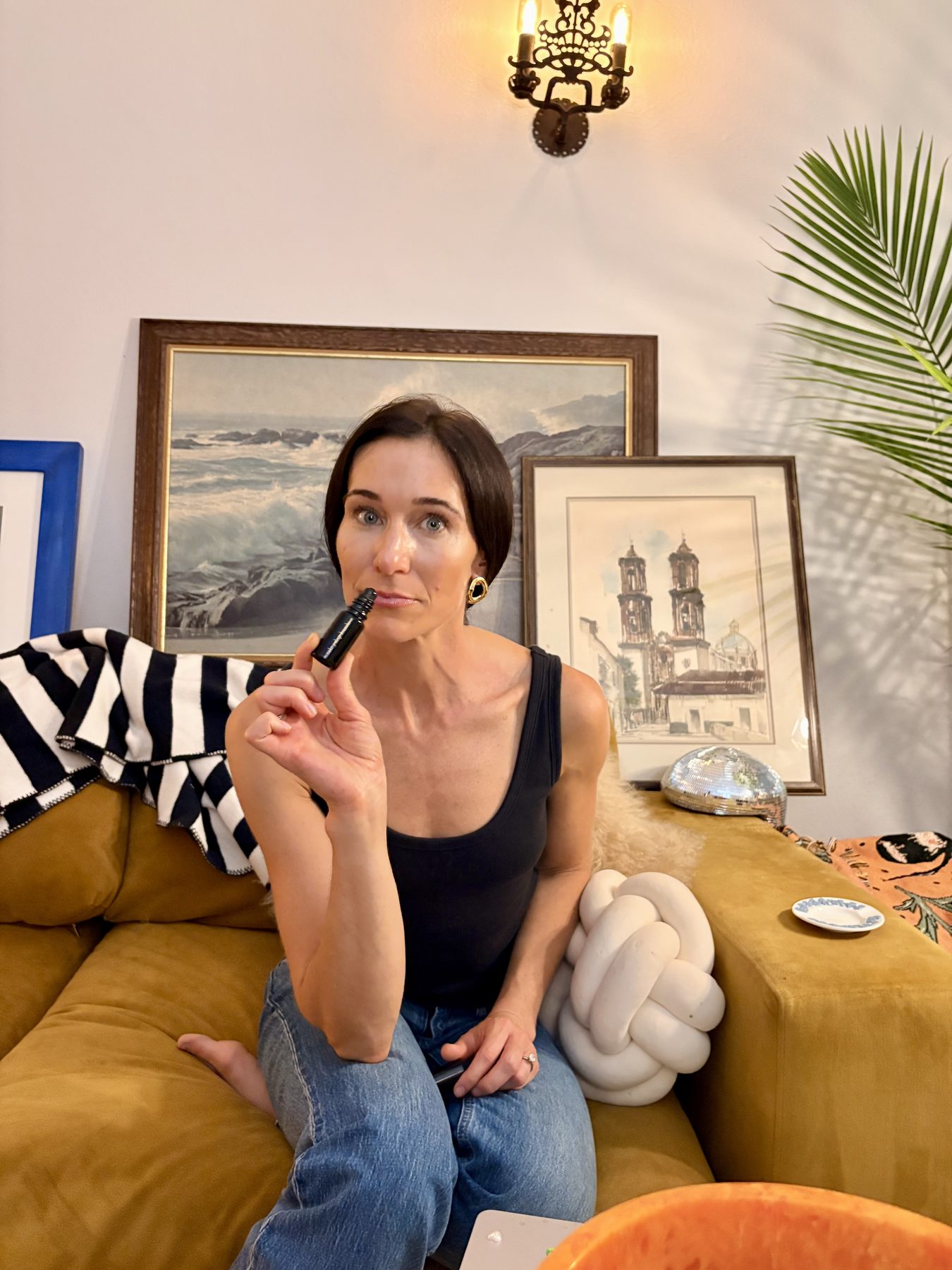 Alicia on a velvet sofa, bringing The Pause up to breathe it in